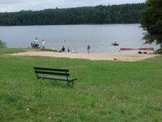 Duża trawiasta plaża z kąpieliskiem na terenie ośrodka Stepol - jezioro Bachotek